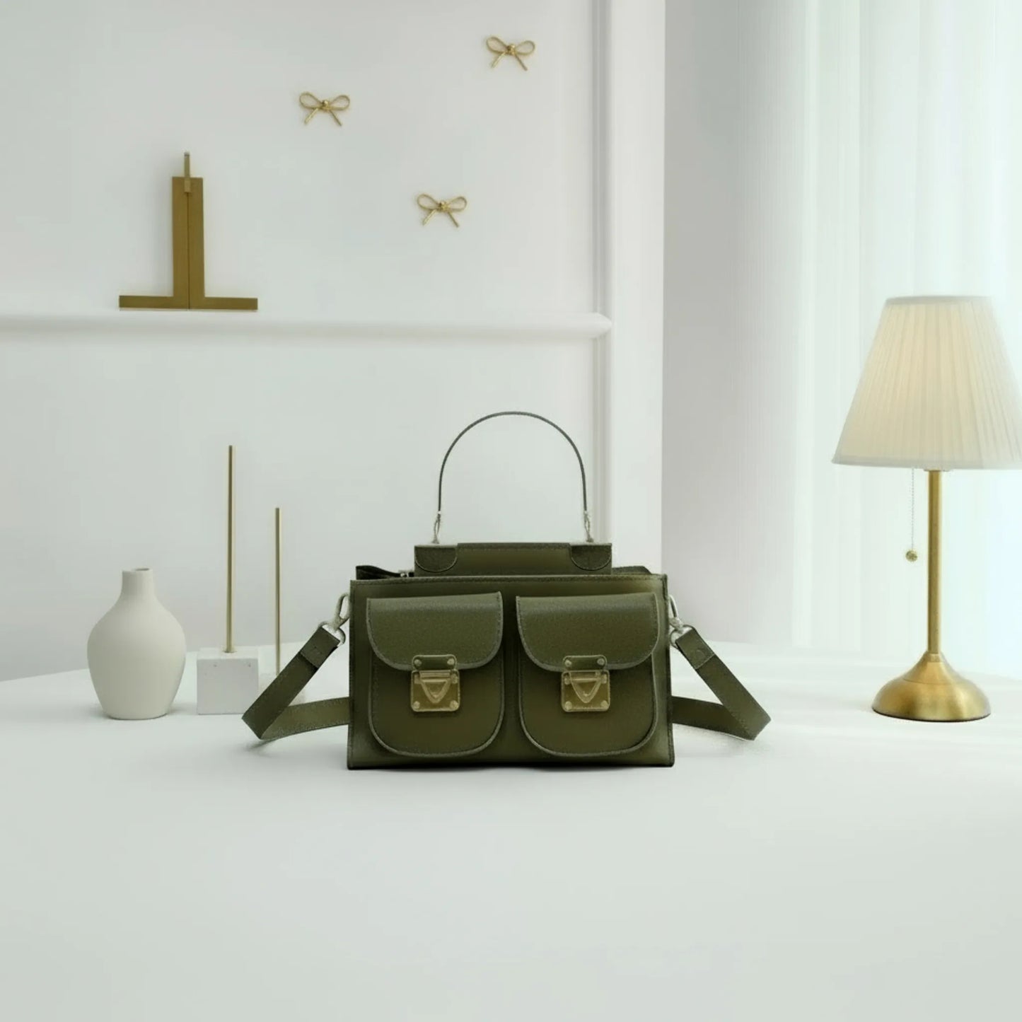Green handbag on a white surface with decorative items in the background