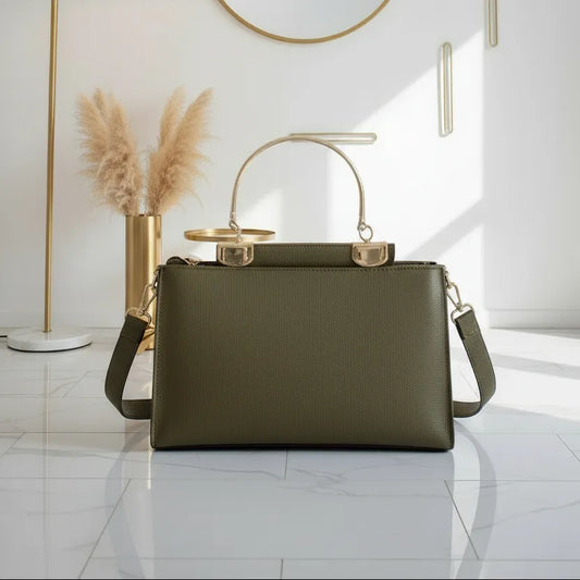 Green handbag on a white marble surface with decorative elements in the background