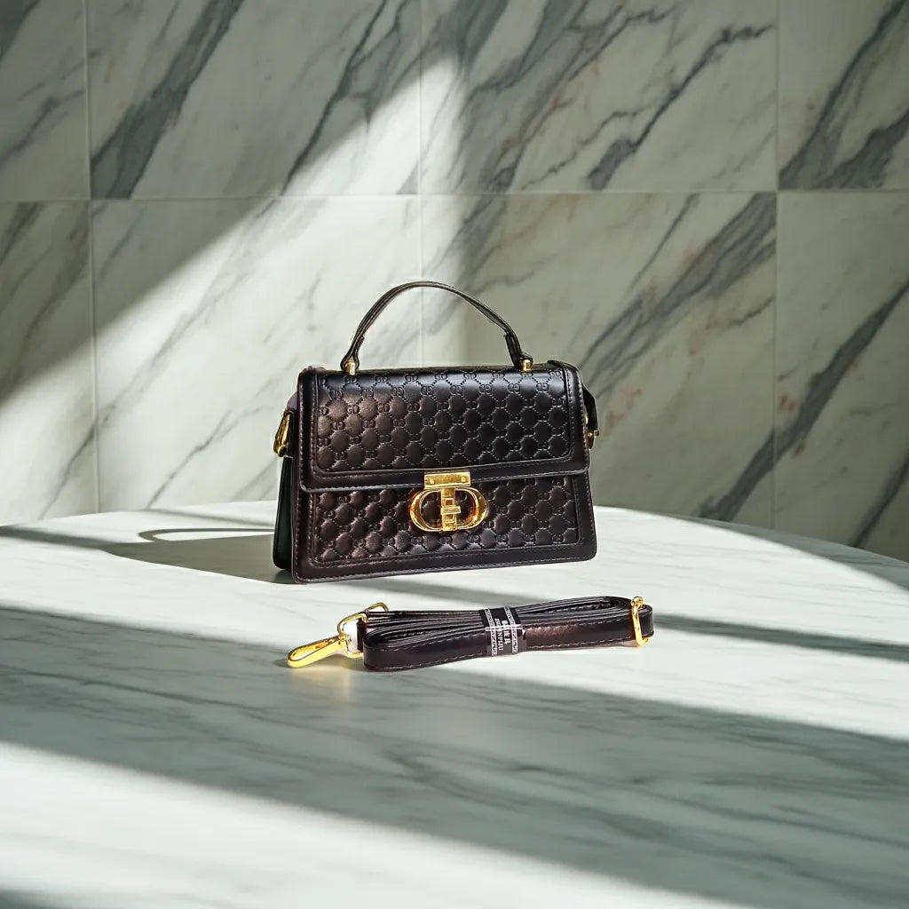 Black quilted handbag with gold accents on a marble surface