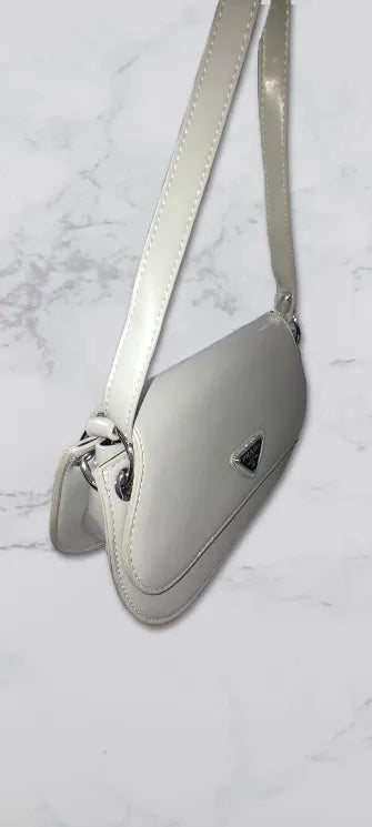 GREY PRADA SHOULDER BAG with a brand logo on a light gray marble background