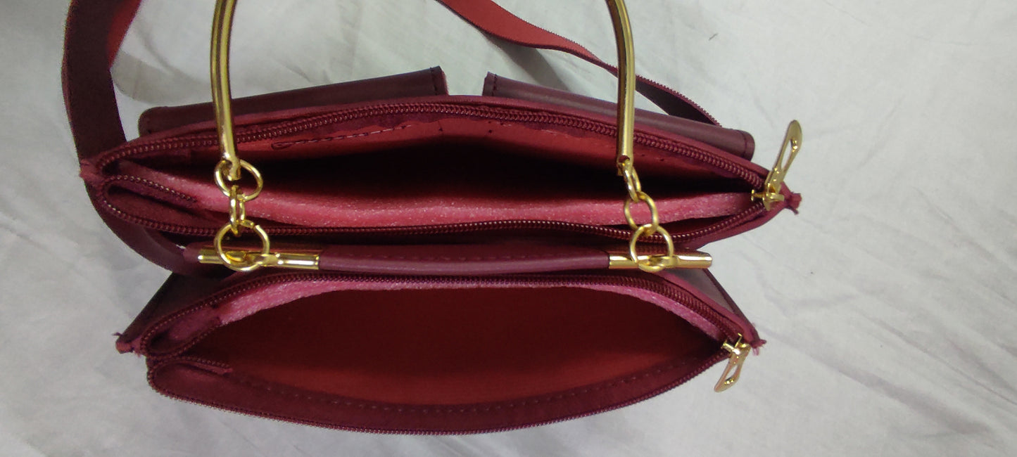 Red handbag with gold accents on a light gray background