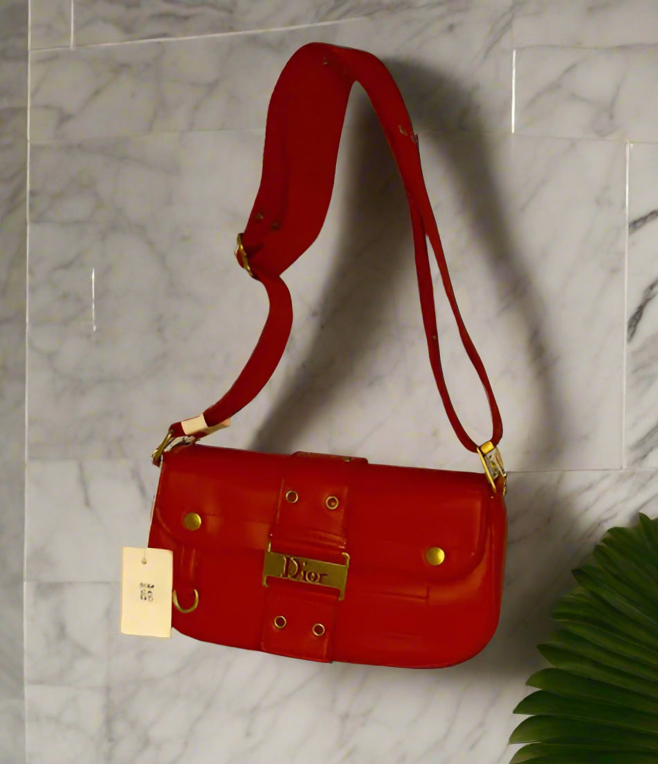 Red handbag with gold accents and long strap cross-body bag