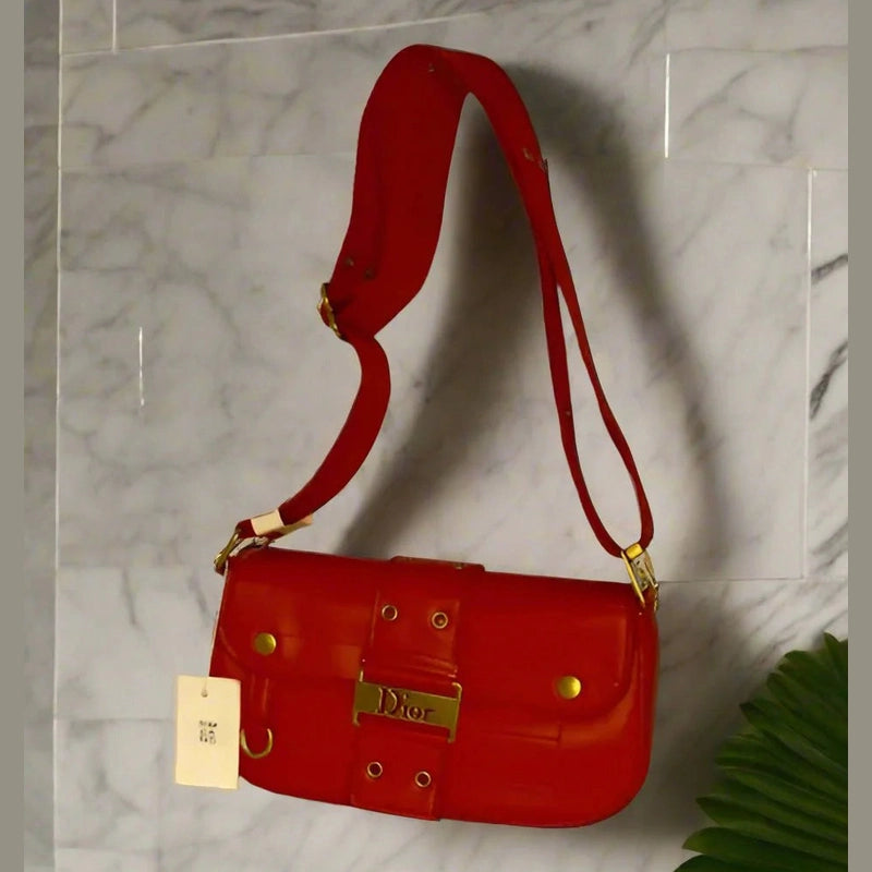 Red handbag with gold accents and long strap cross-body bag