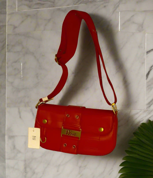 Red handbag with gold accents and long strap cross-body bag