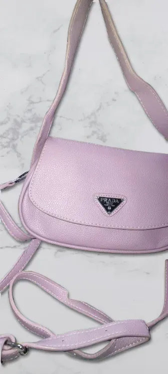 Pink handbag with Prada logo on a marble background