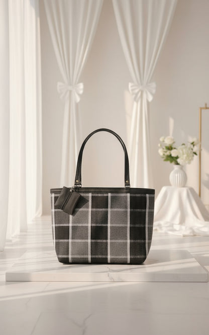 Black and white checkered handbag on a marble surface with a neutral background