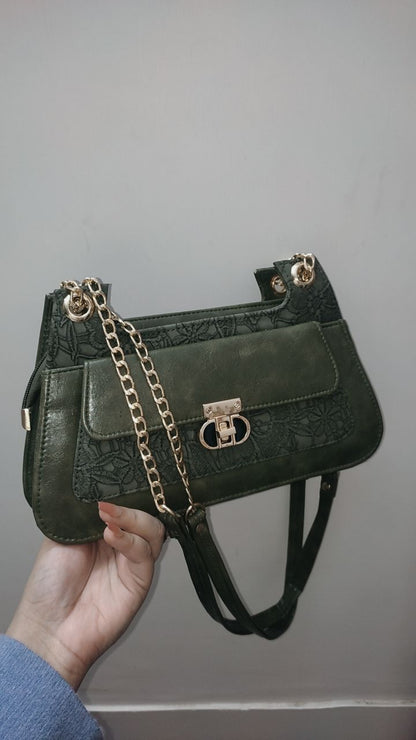 OLIVE GREEN handbag with a chain detail held by a person against a plain background