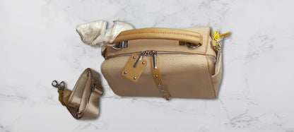 brown handbag with detachable strap on a light gray background