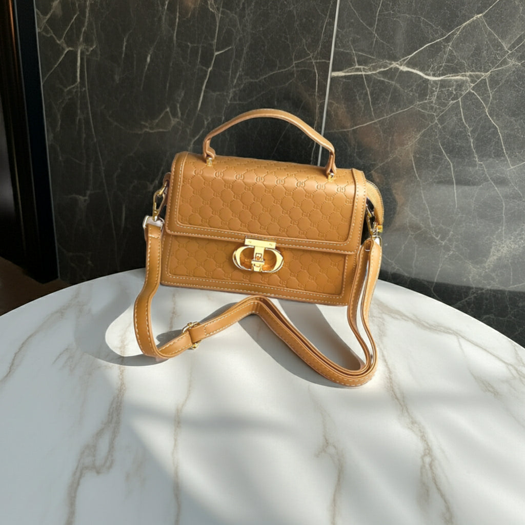 Brown handbag with gold accents on a marble surface