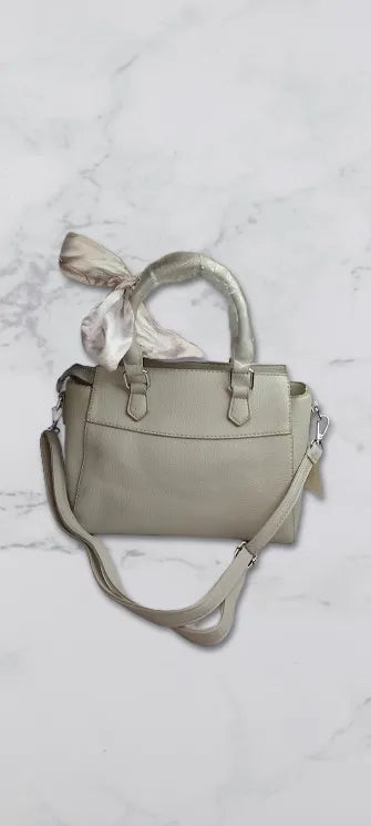 Light gray handbag with a matching scarf on a light marble background