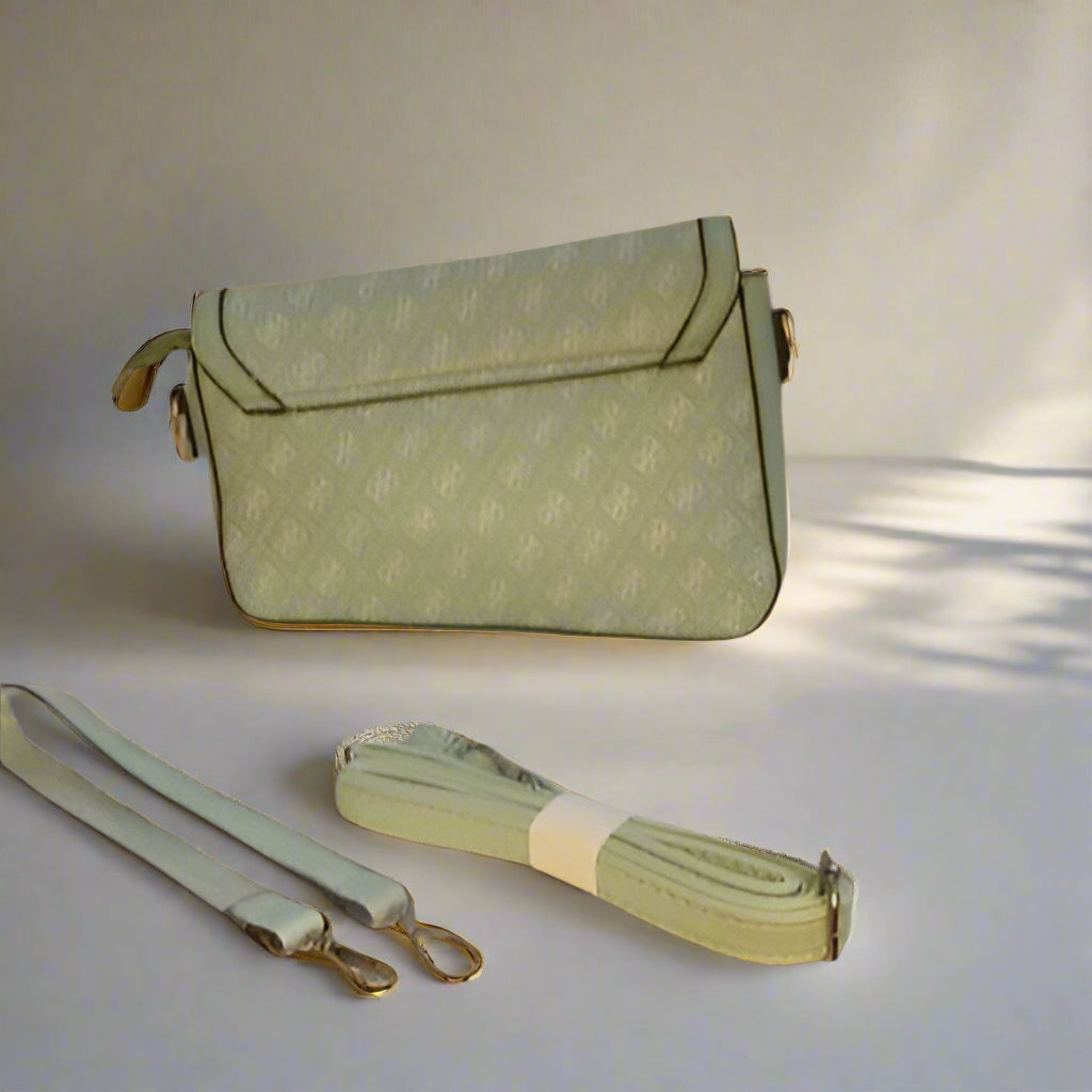 Green handbag with matching strap on a light background