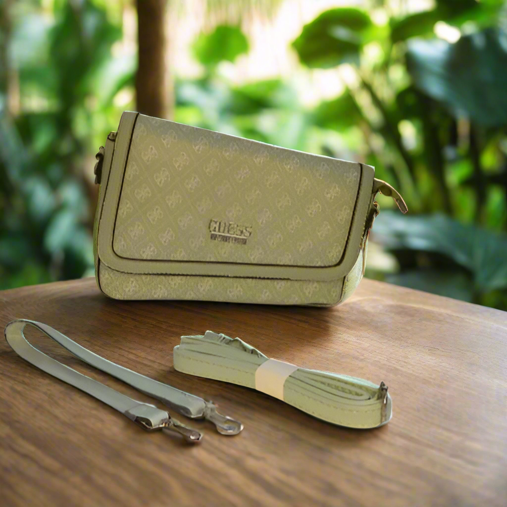 Green handbag with matching strap on a satin background