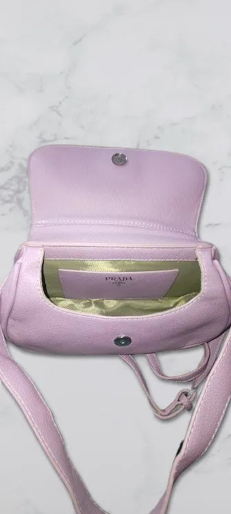 purple handbag with Prada logo on a light gray background