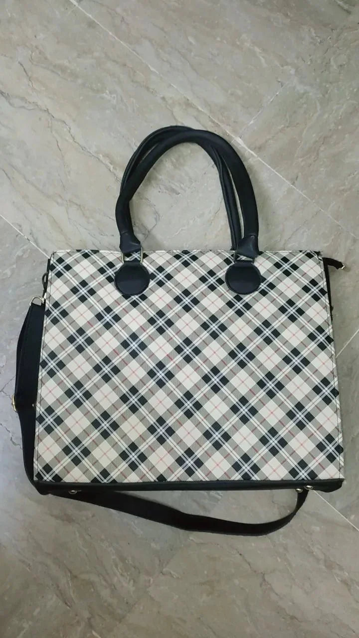 Plaid handbag with black straps on a tiled floor
