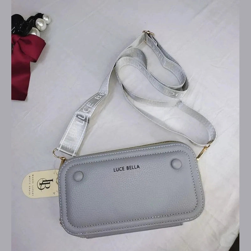 Gray crossbody bag with 'Luce Bella' branding on a white background