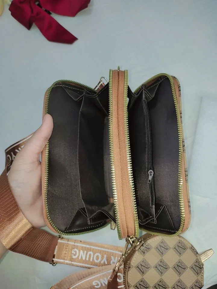 Brown leather wallet with gold zipper held by a hand on a light gray background