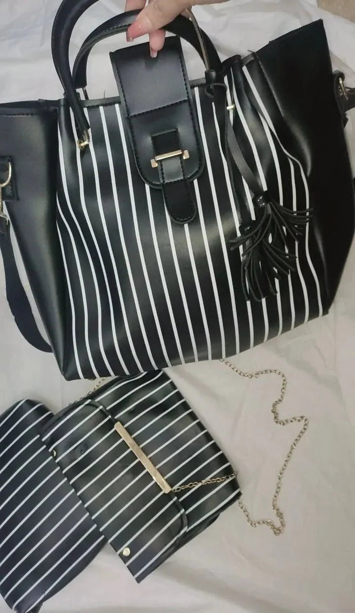 Black and white striped handbag with matching pouch on a light background