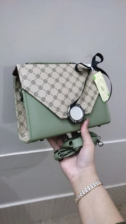 Green handbag with beige pattern held by a hand against a neutral background