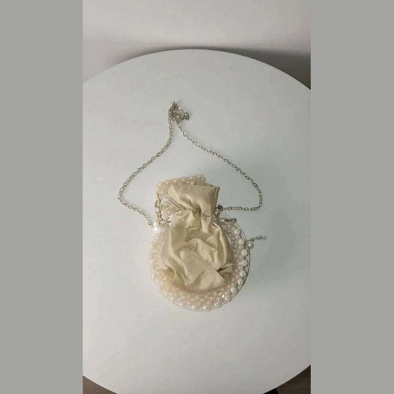 Vintage-style handbag with chain strap on a light fabric background