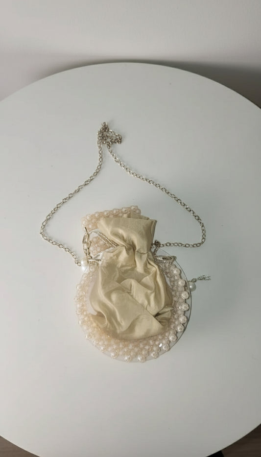 Vintage-style handbag with chain strap on a light fabric background