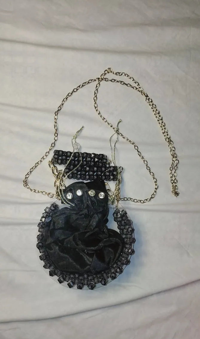 Black cat pendant necklace on a white fabric background