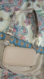 Beige handbag with 'Luce Bell' branding on a patterned fabric background