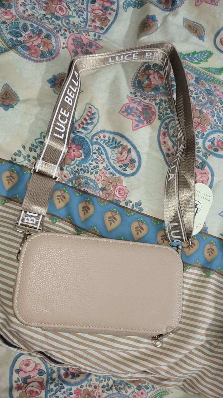 Beige handbag with 'Luce Bell' branding on a patterned fabric background
