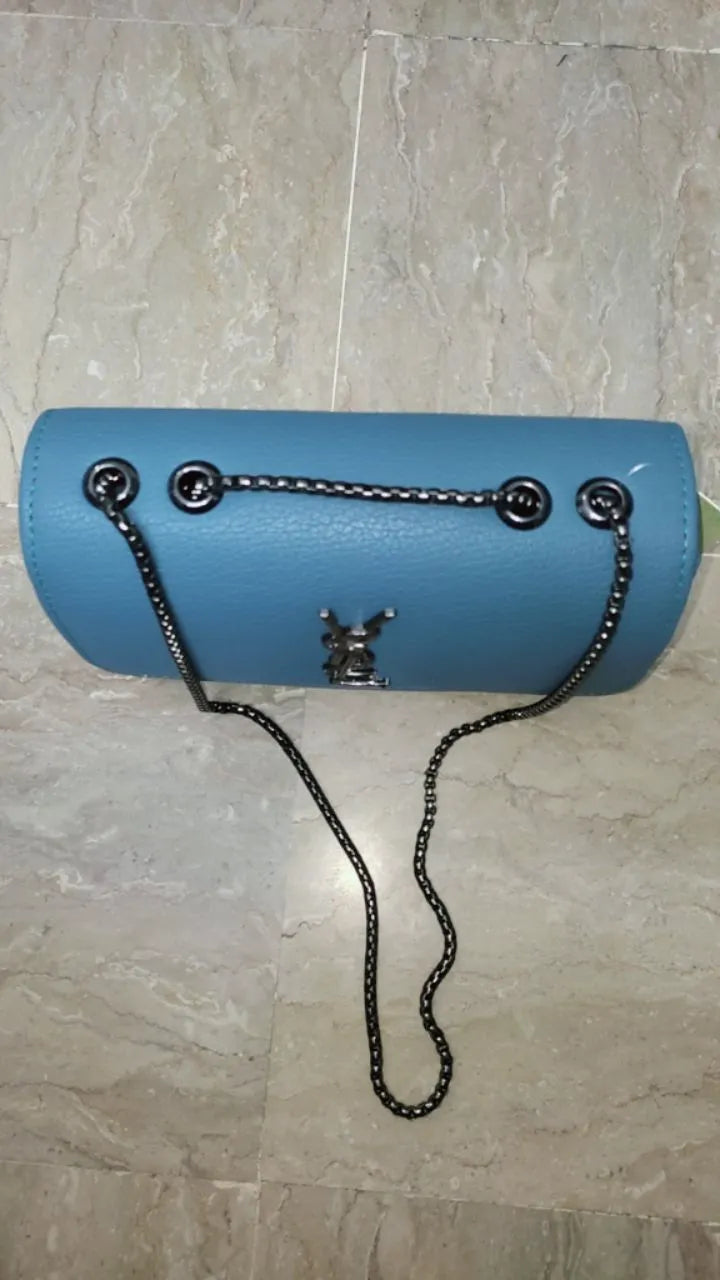 Blue handbag with a chain strap on a tiled floor
