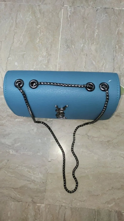 Blue handbag with a chain strap on a tiled floor