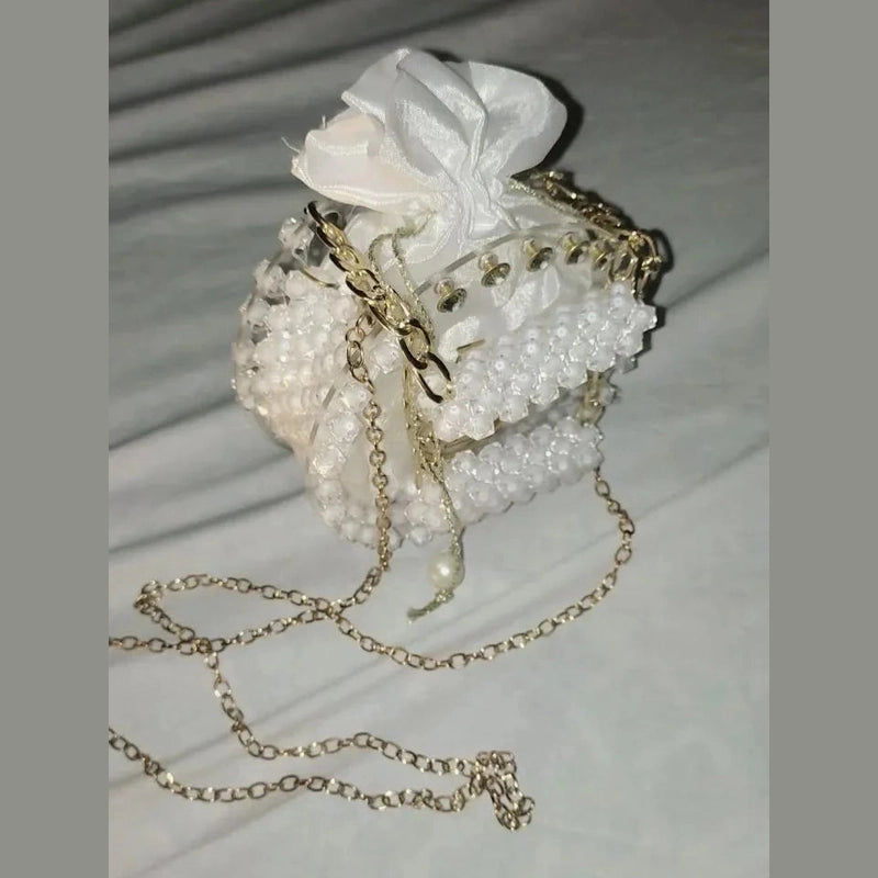 Decorative handbag with pearls and a white flower on a light background