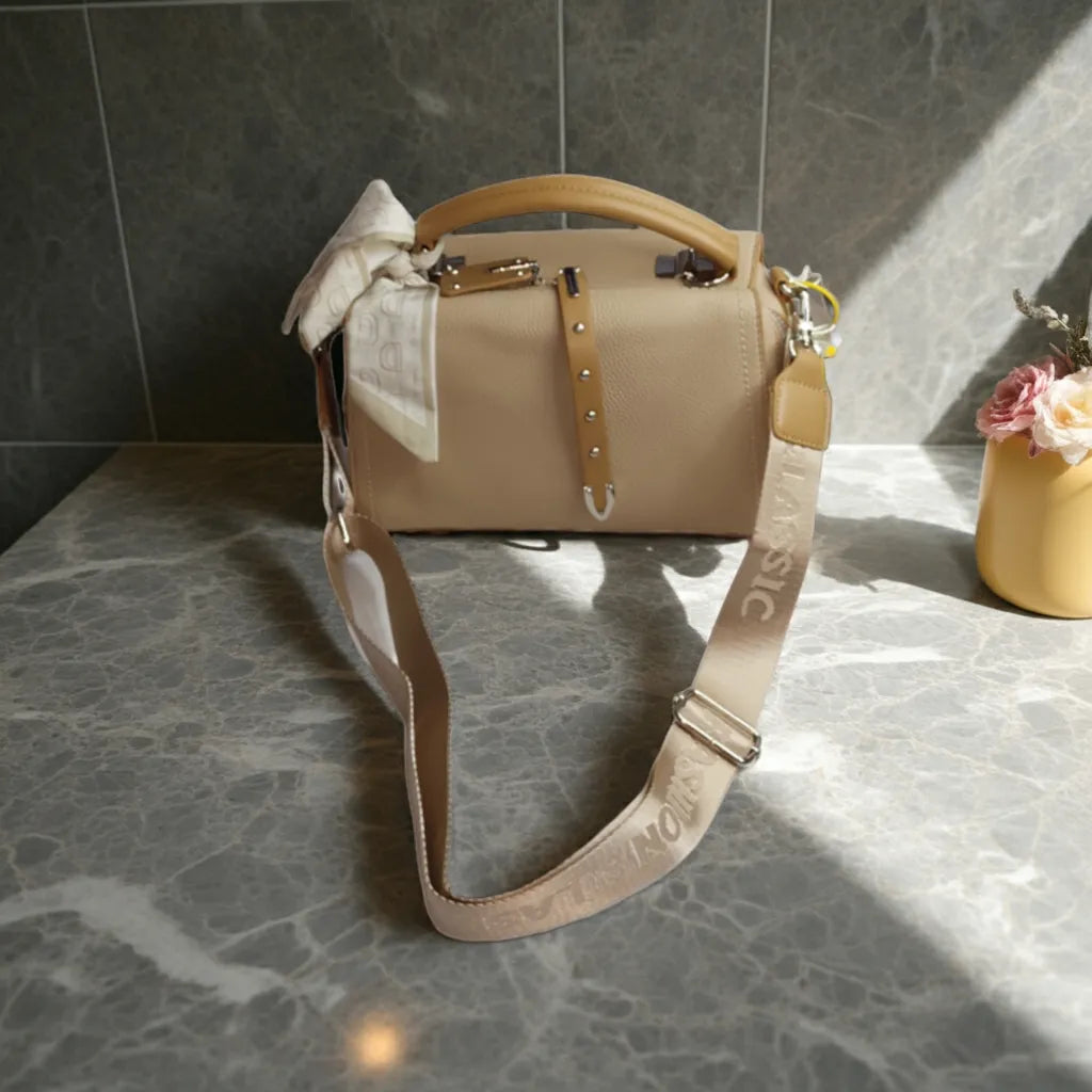 Beige handbag with a bow on a marble surface