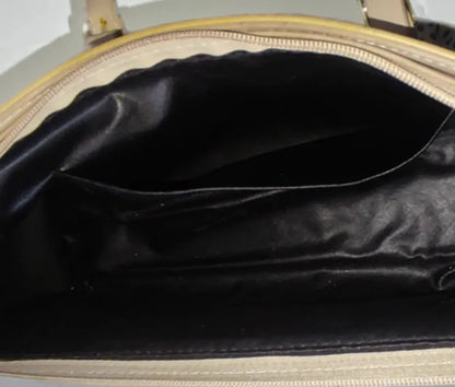 Close-up of a black handbag with a beige interior.