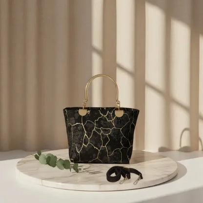 Black marble-patterned handbag on a marble surface with a neutral background